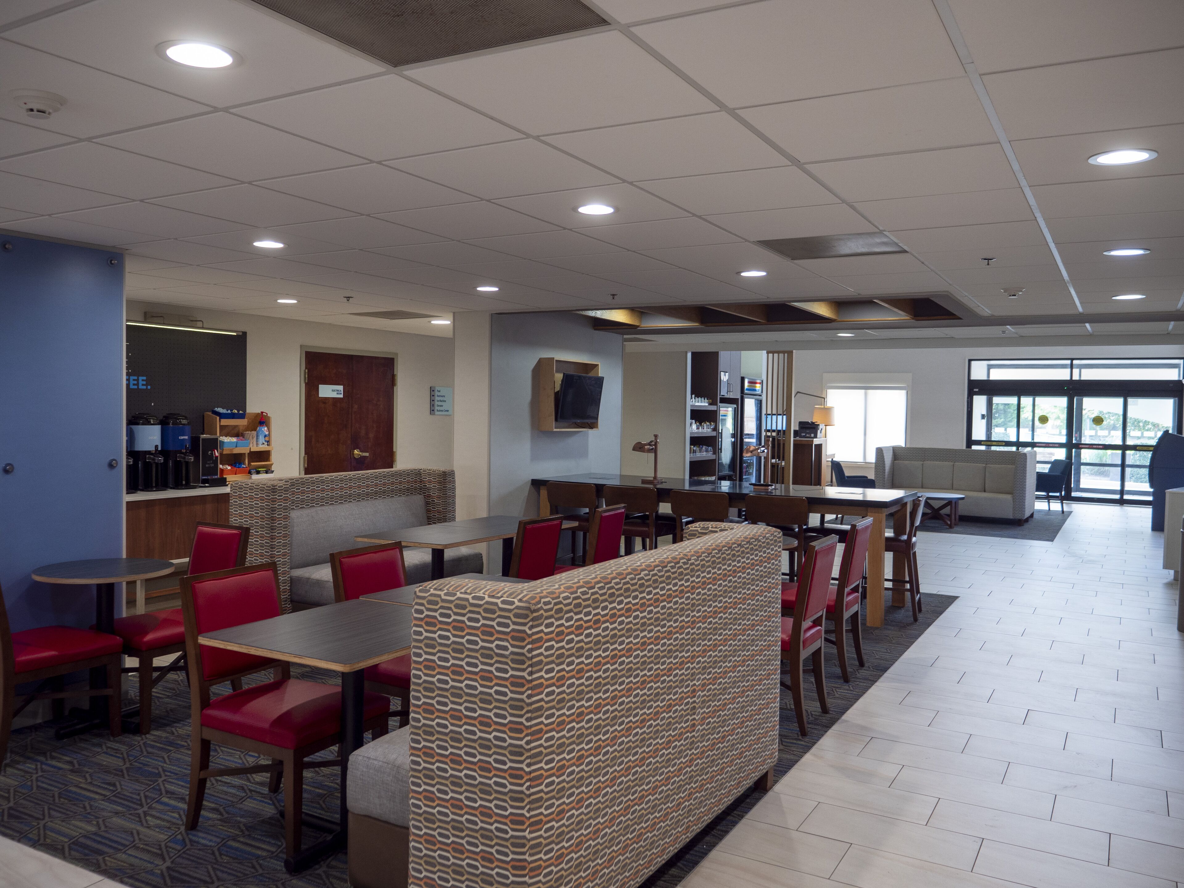 A spacious indoor area with a seating area, a counter with a coffee machine, and a refrigerator.
