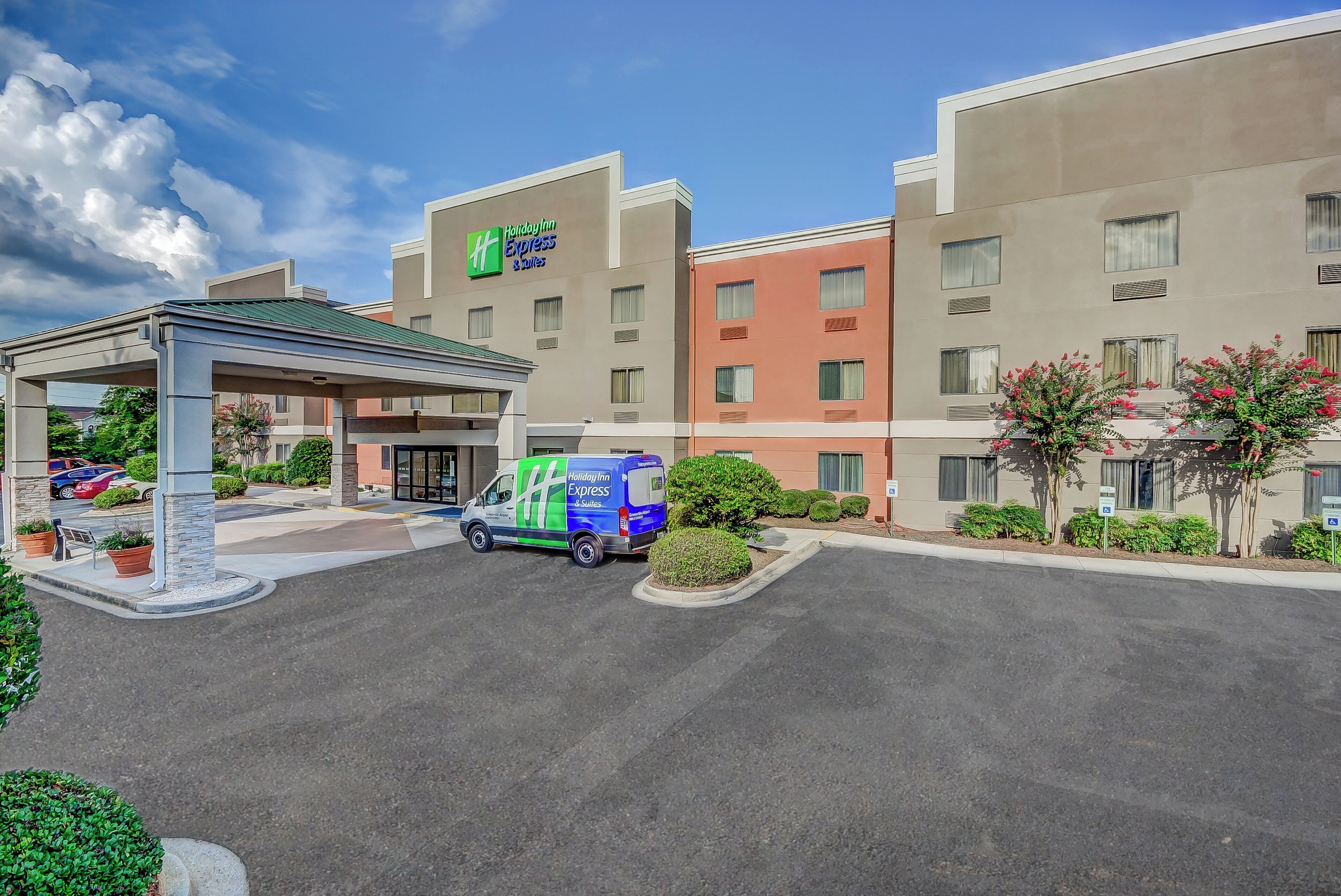 Un hôtel Holiday Inn Express & Suites doté d’un parking couvert et d’un fourgon de livraison.