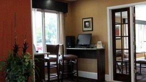 A room with a desk, computer, chairs, a window, and a door. - Quality Inn & Suites Greenville near downtown (Greenville)