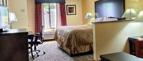 Une chambre d’hôtel avec un lit, un bureau avec un ordinateur, une télévision et deux lampes.