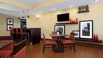 A restaurant with booths and tables, a bar area, and wall-mounted decor.