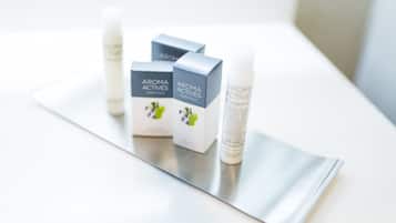 Trois boîtes et deux flacons de la gamme Aroma Actives Essentials, placés sur une surface réfléchissante.
