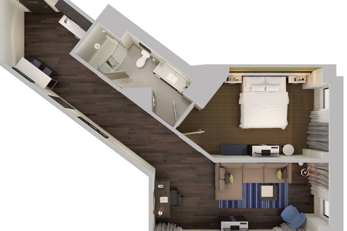 A modern hotel room with a bed, a desk, a chair, a small table, and a bathroom.
