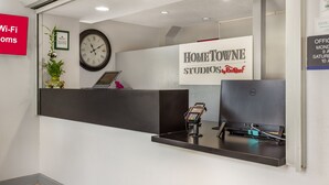Una reception con una sveglia, un cartello con scritto Home Townne Studios e il simbolo del Wi-Fi.