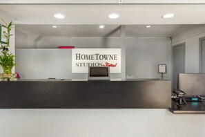 Una recepción con un cartel de Home Towne Studios, una computadora Dell y un terminal de pago.