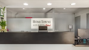 A reception desk with a sign for Home Towne Studios, a Dell computer, and a payment terminal.