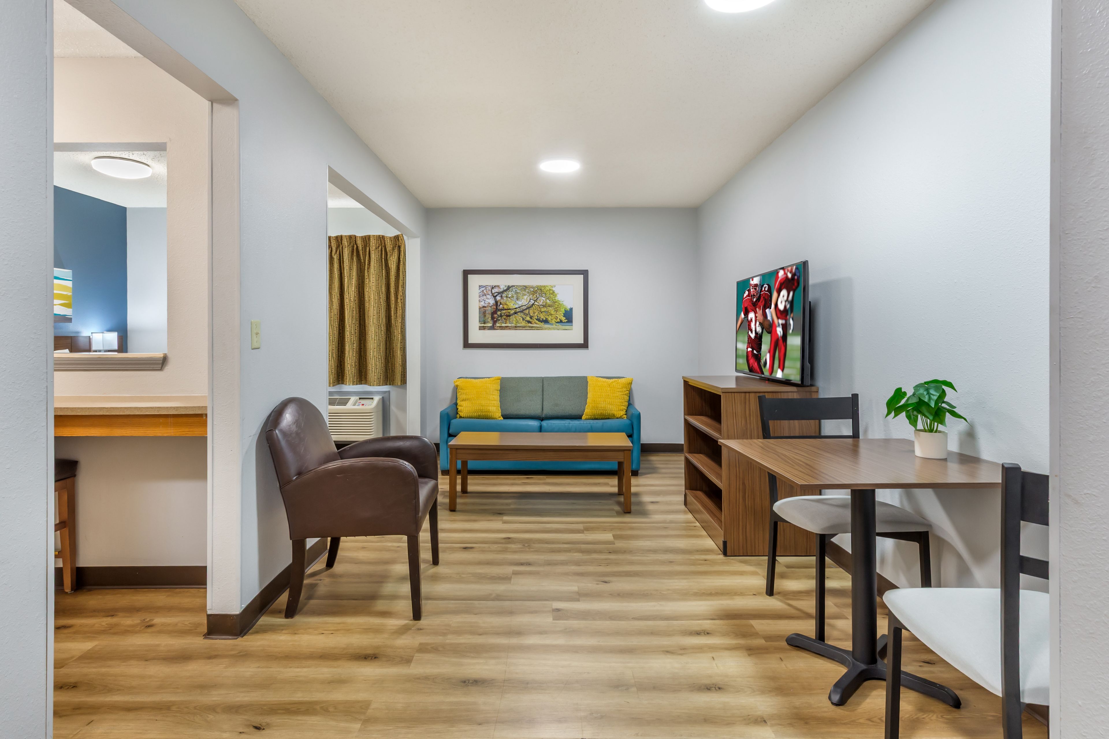 Un salon moderne avec un canapé, une table basse et un téléviseur posé sur un meuble en bois.