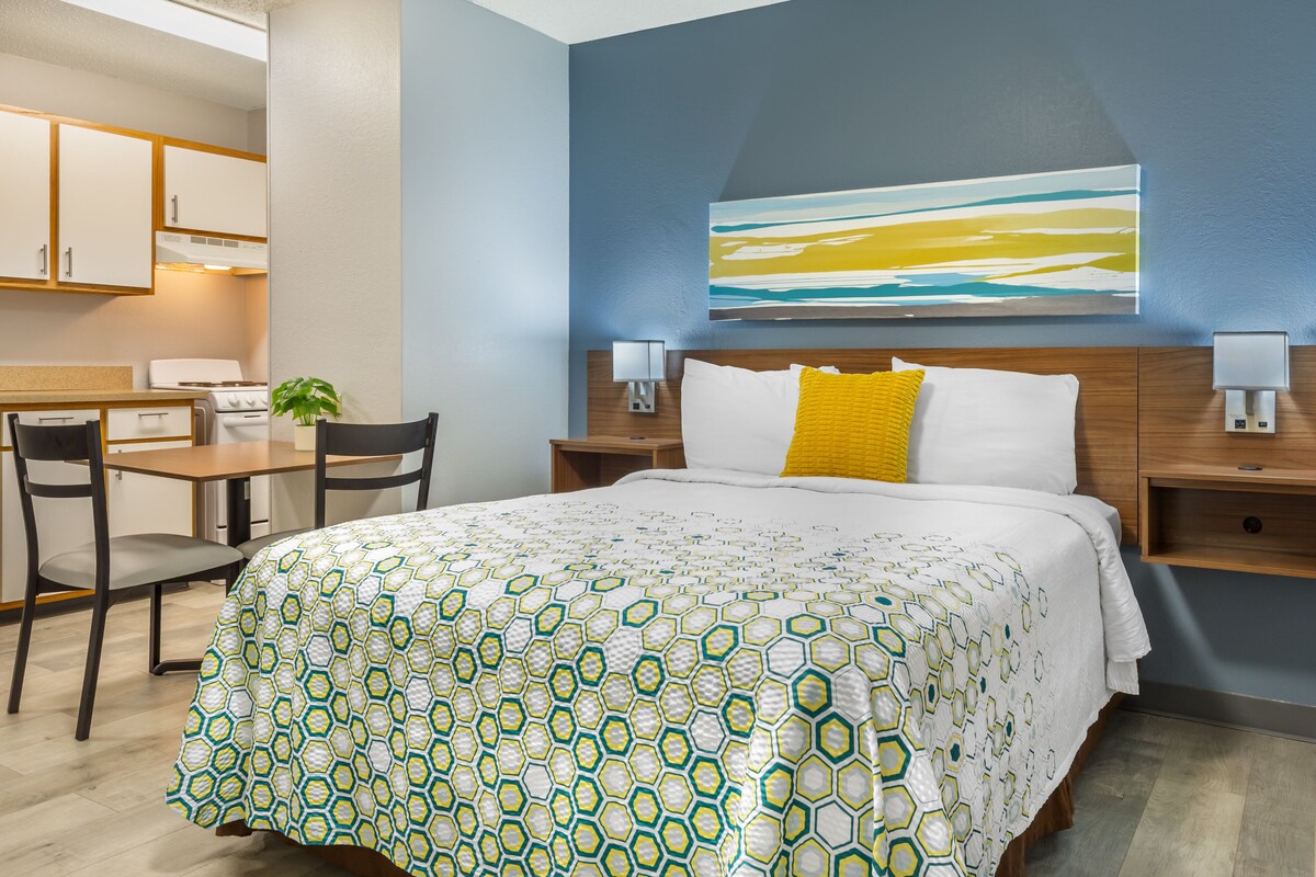 Une chambre d’hôtel avec un lit, un bureau et une chaise.