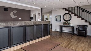 A reception area with a counter, a staircase, and a seating area.