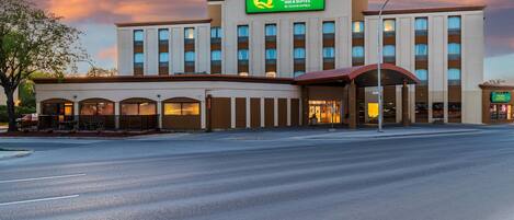 Een hotel met een opvallend bord 'Quality Inn a Suites by Choice Hotels', een ruime entree met een overdekt gedeelte en een parkeerplaats ervoor.