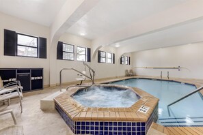 A swimming pool with a hot tub, a towel rack, and a 'TOWELS ONLY' sign. - Best Western Alamo Suites (San Antonio)