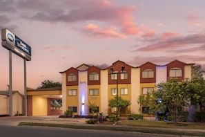 A multi-story hotel with a sign reading "Best Western Alamo Suites."