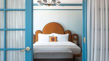 A bedroom with a bed, a nightstand, a telephone, and a ceiling fan.