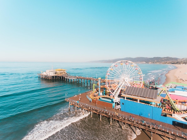 A pier with a Ferris wheel and a beach in the background. - The Georgian, in The Unbound Collection by Hyatt (Santa Monica)