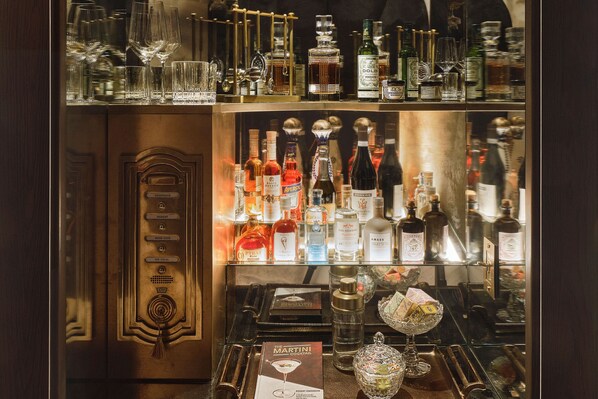 A bar area with various liquor bottles, glasses, and a menu. - The Georgian, in The Unbound Collection by Hyatt (Santa Monica)