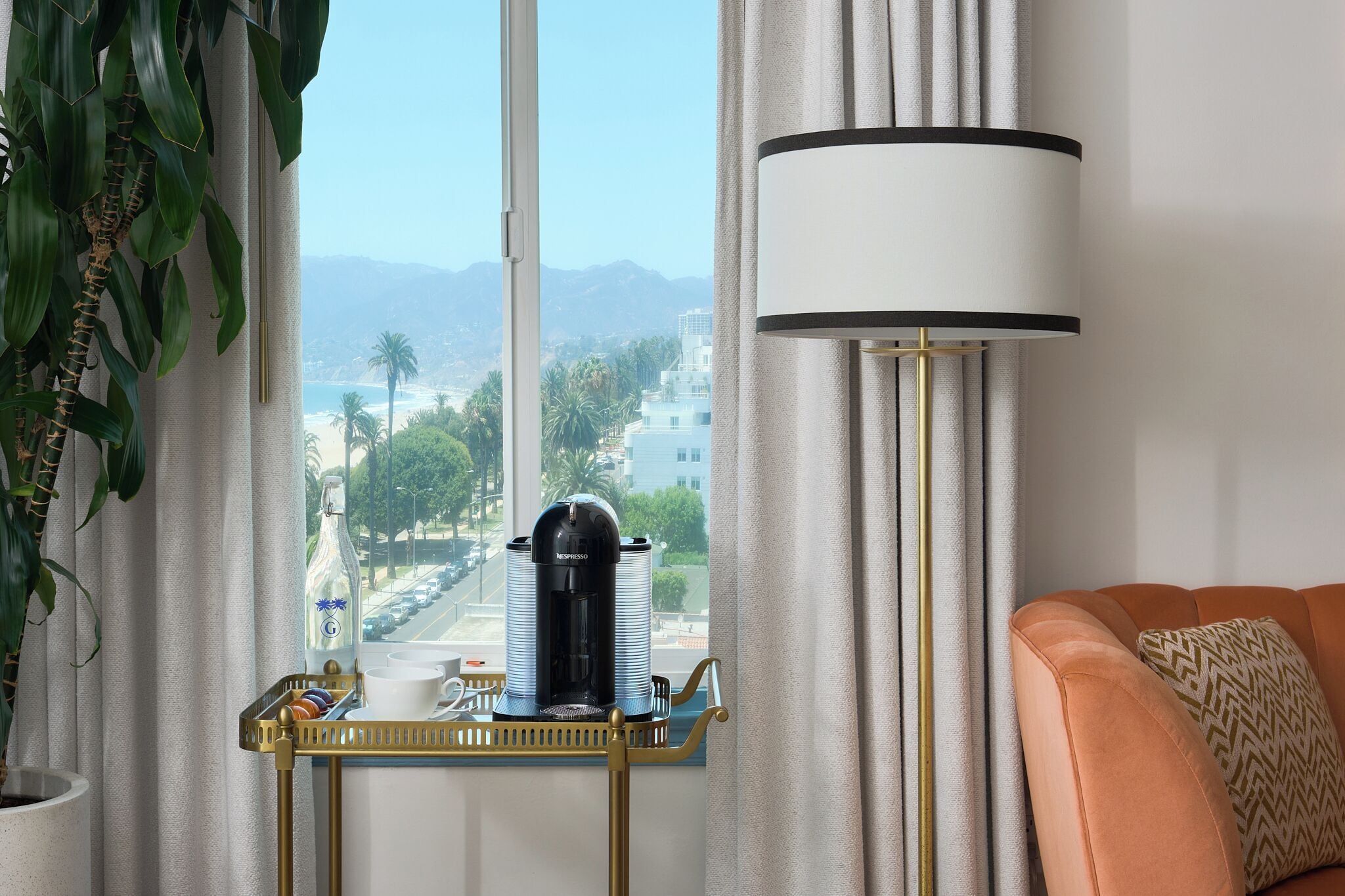 Una habitación con vistas a la playa, máquina de café Nespresso, una lámpara y un sofá.