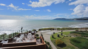 Una terraza con mobiliario exterior con vistas a una playa y al océano.