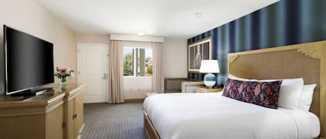 Una habitación de hotel con cama, televisión, escritorio y ventana.