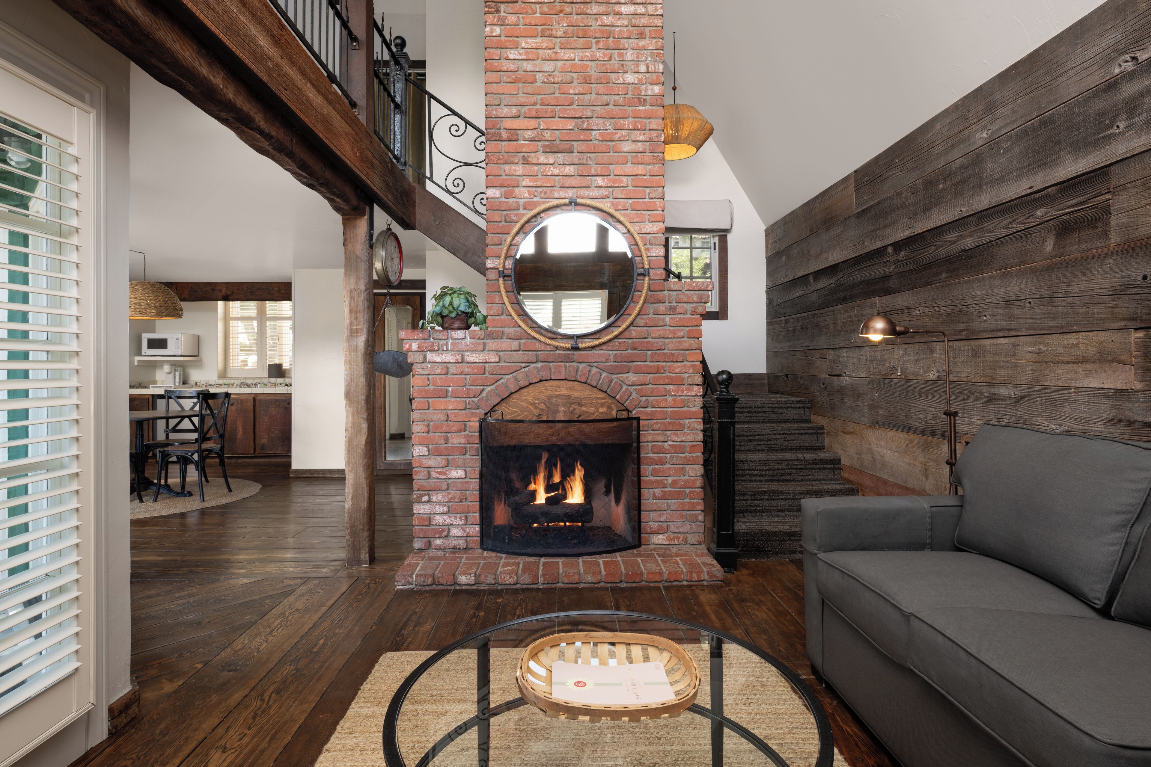 Una sala de estar con chimenea, un sofá, un comedor y una escalera.