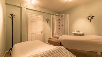 Two comfortable beds with crisp linens, a compact sink, and a mirror complete this cozy space.