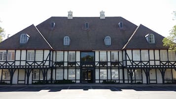 Un bâtiment de style Tudor traditionnel, doté d’une façade symétrique, de nombreuses fenêtres et d’une entrée centrale.