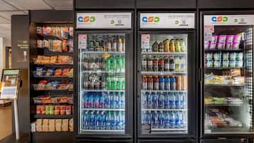 Three beverage vending machines stocked with various drinks and snacks.