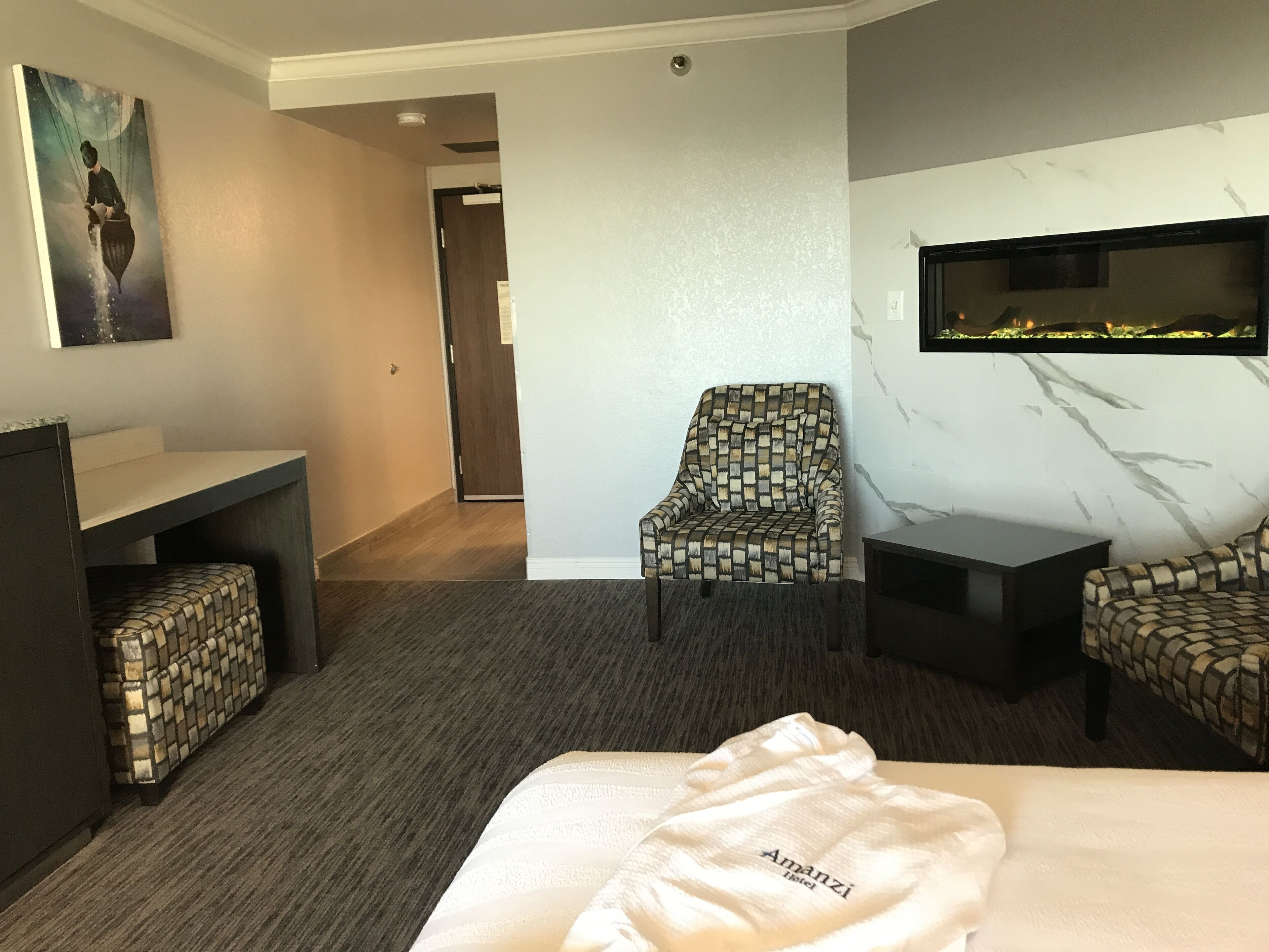Ein Hotelzimmer mit Bett, Schreibtisch, Stuhl und Fernseher.