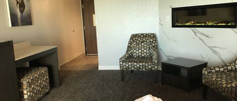 A hotel room with a bed, a desk, a chair, and a TV.