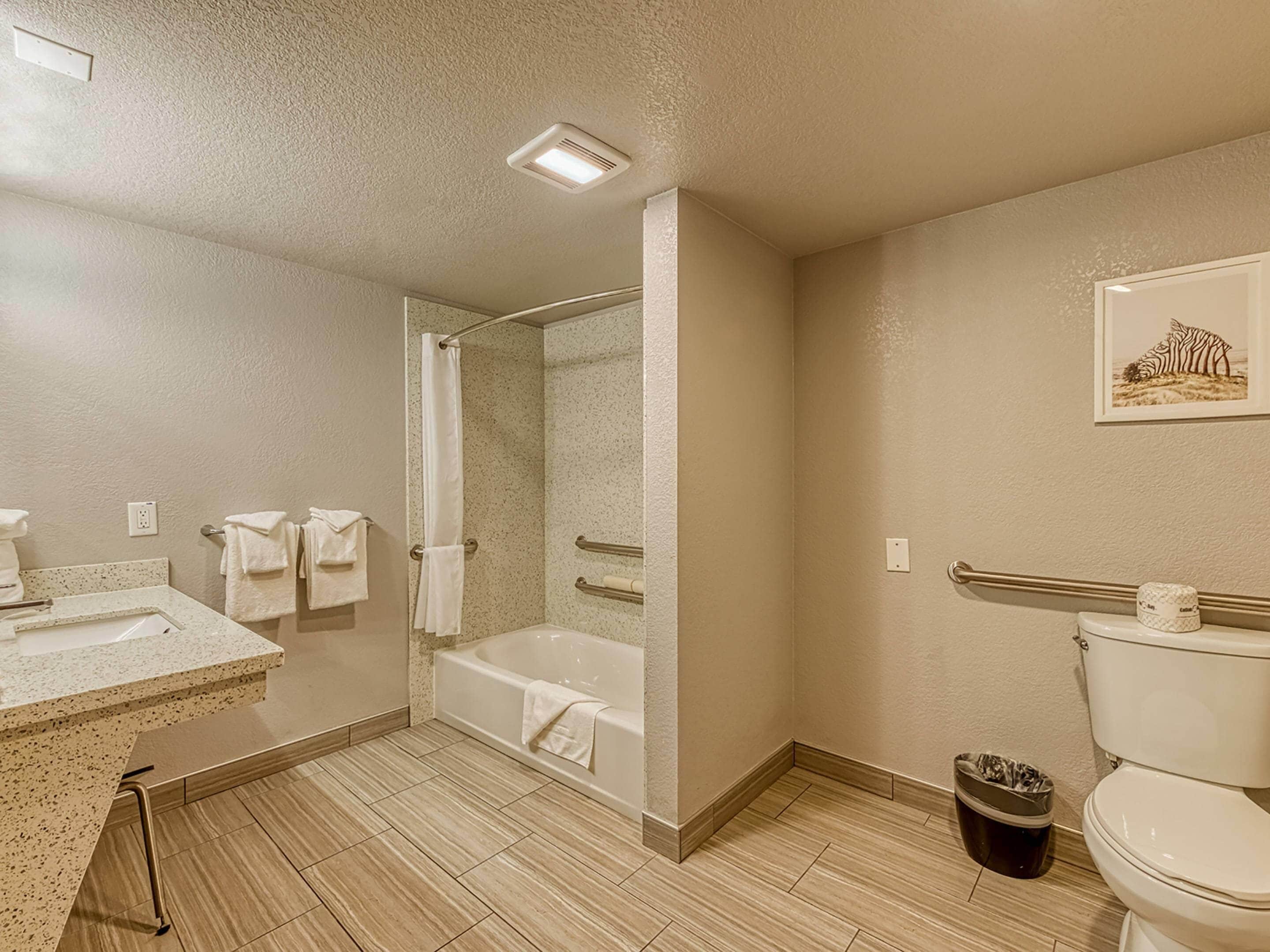 Un baño con bañera, inodoro, lavamanos y ducha.