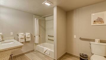 Een badkamer met een bad, toilet, wastafel en douche.