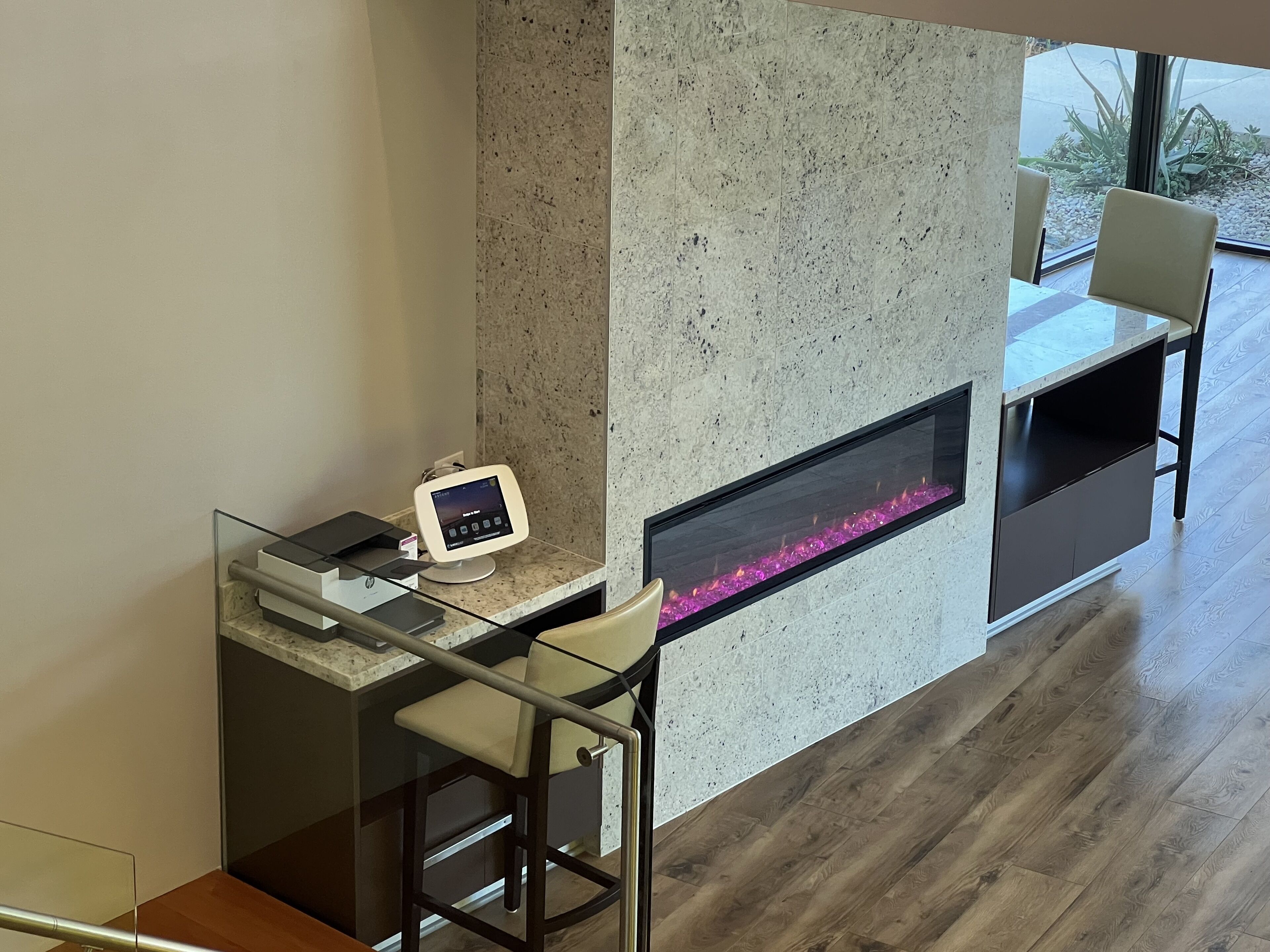 A modern bar area with a digital screen, a fireplace, and a seating area.