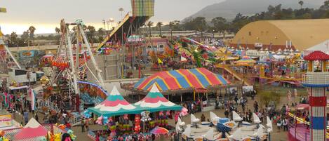 A bustling fairground with various rides and attractions.