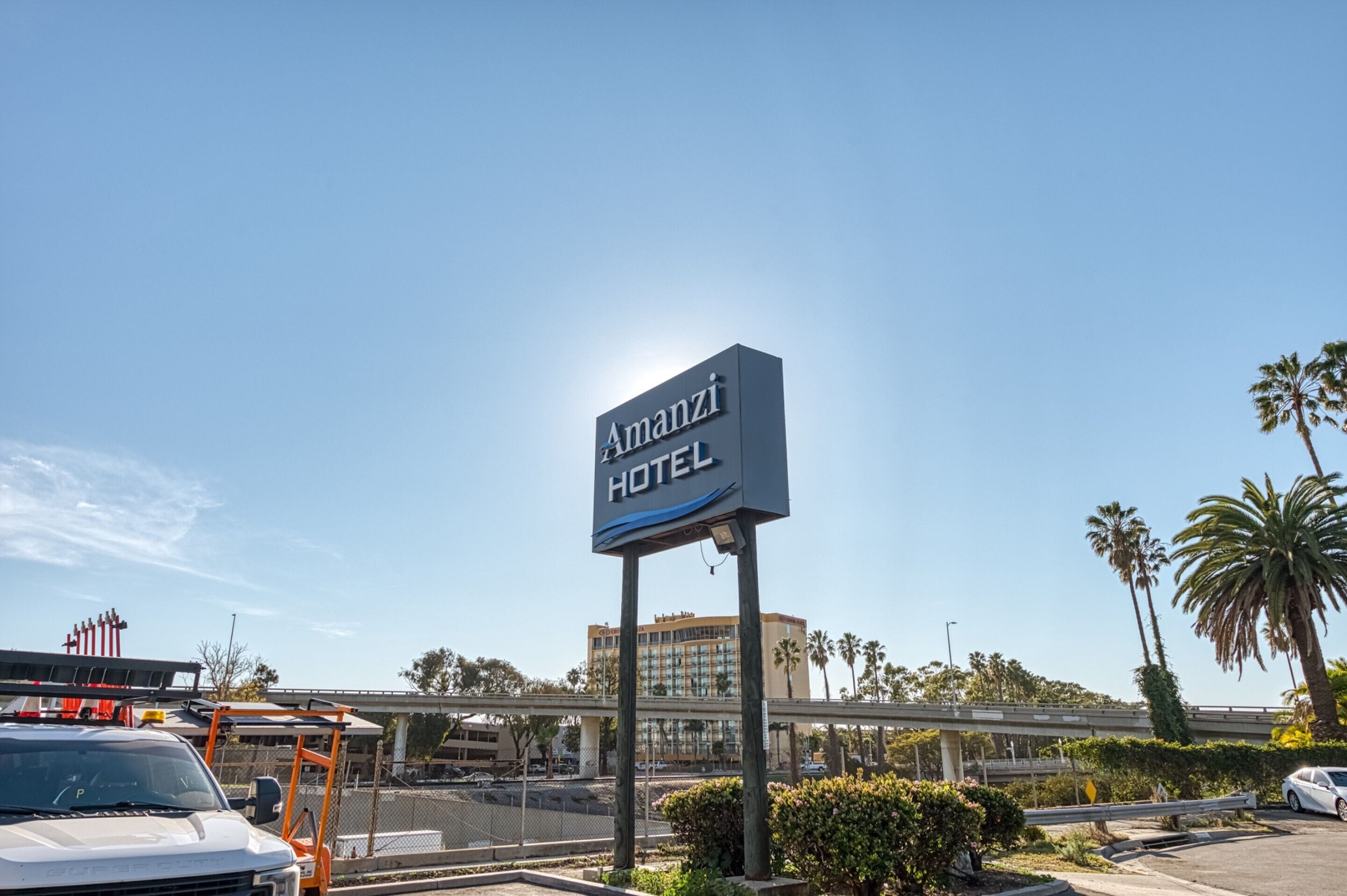 Señal del Hotel Amanzi con vista despejada al estacionamiento y edificios circundantes.
