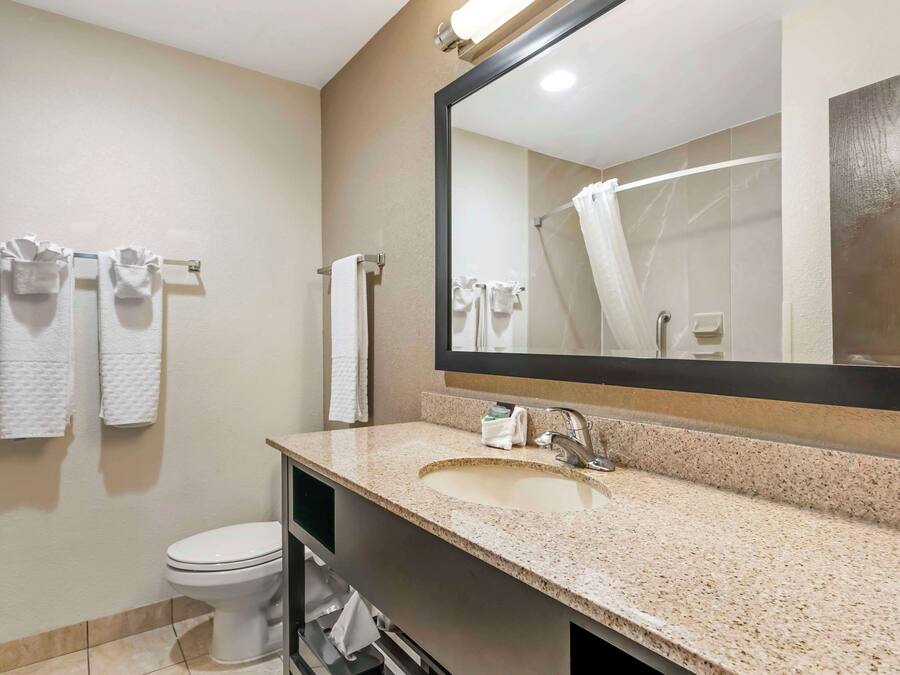 Een badkamer met een wastafel, spiegel en toilet.