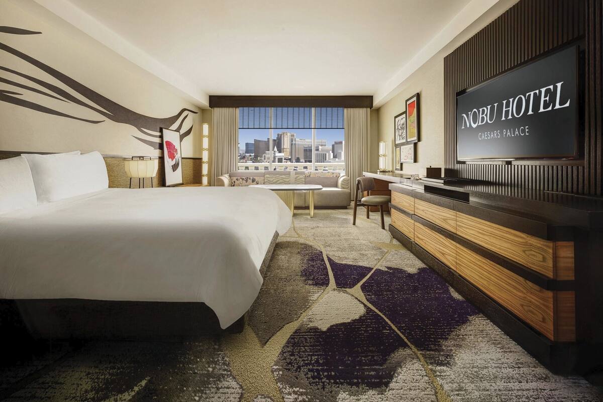 Une chambre d’hôtel avec un grand lit, un bureau, une télévision et une vue sur la ville.