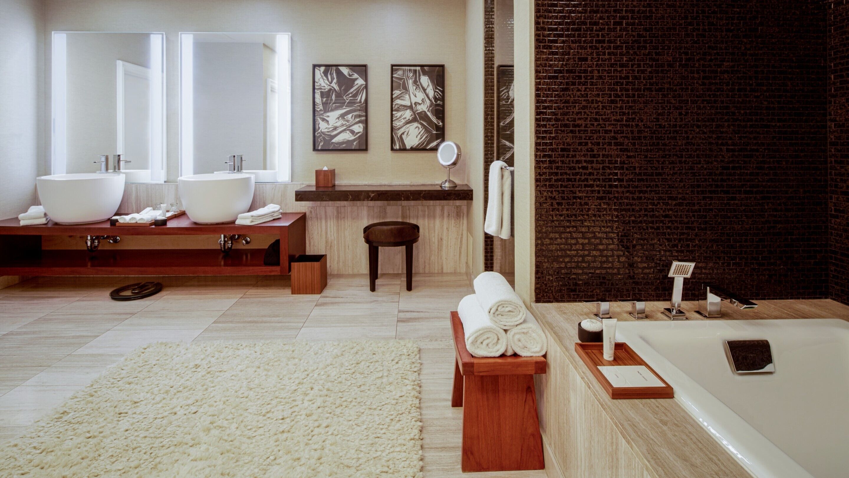 A modern bathroom with a large bathtub, two sinks, a vanity, and a mirror.