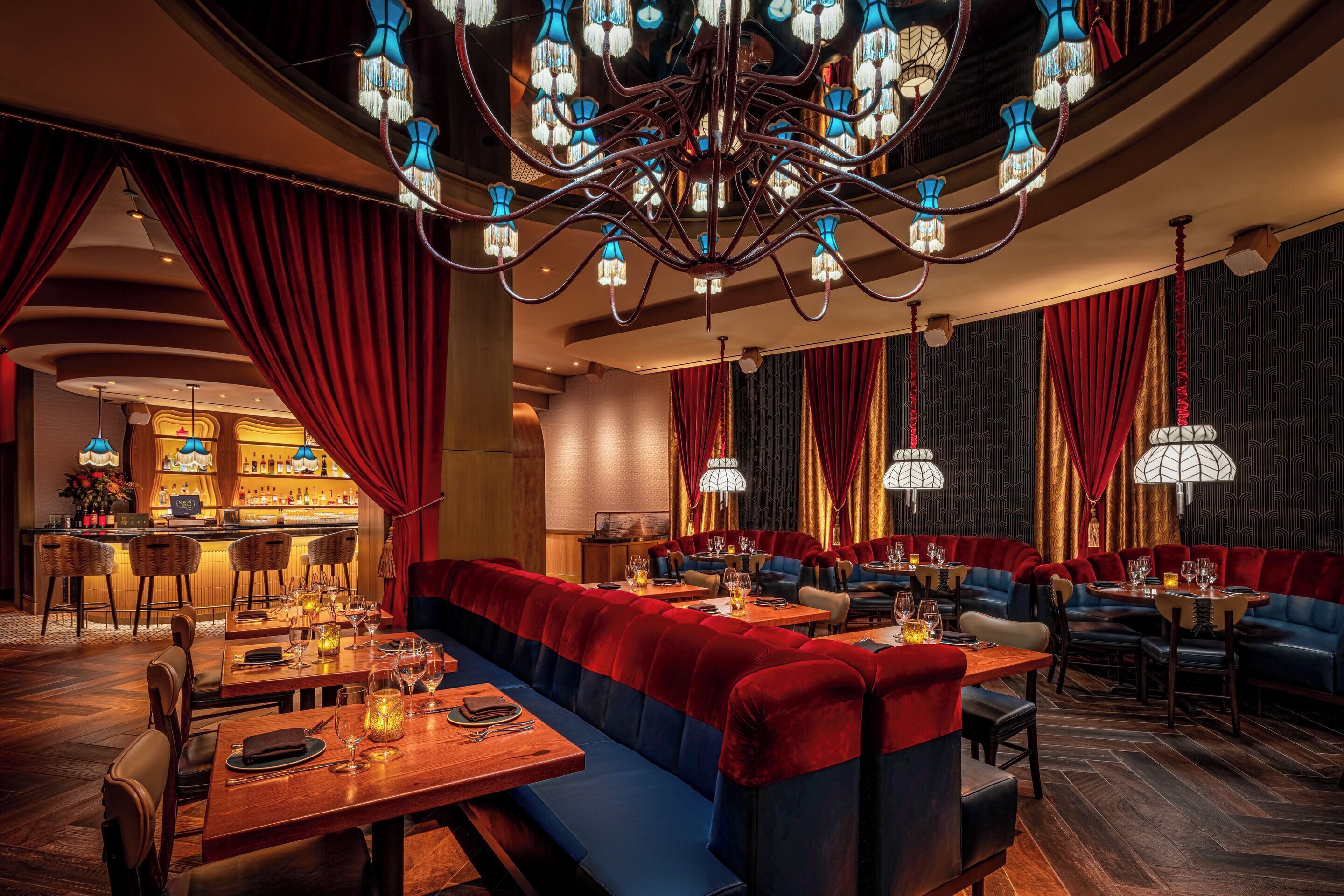 A restaurant with a bar, booths, and tables.