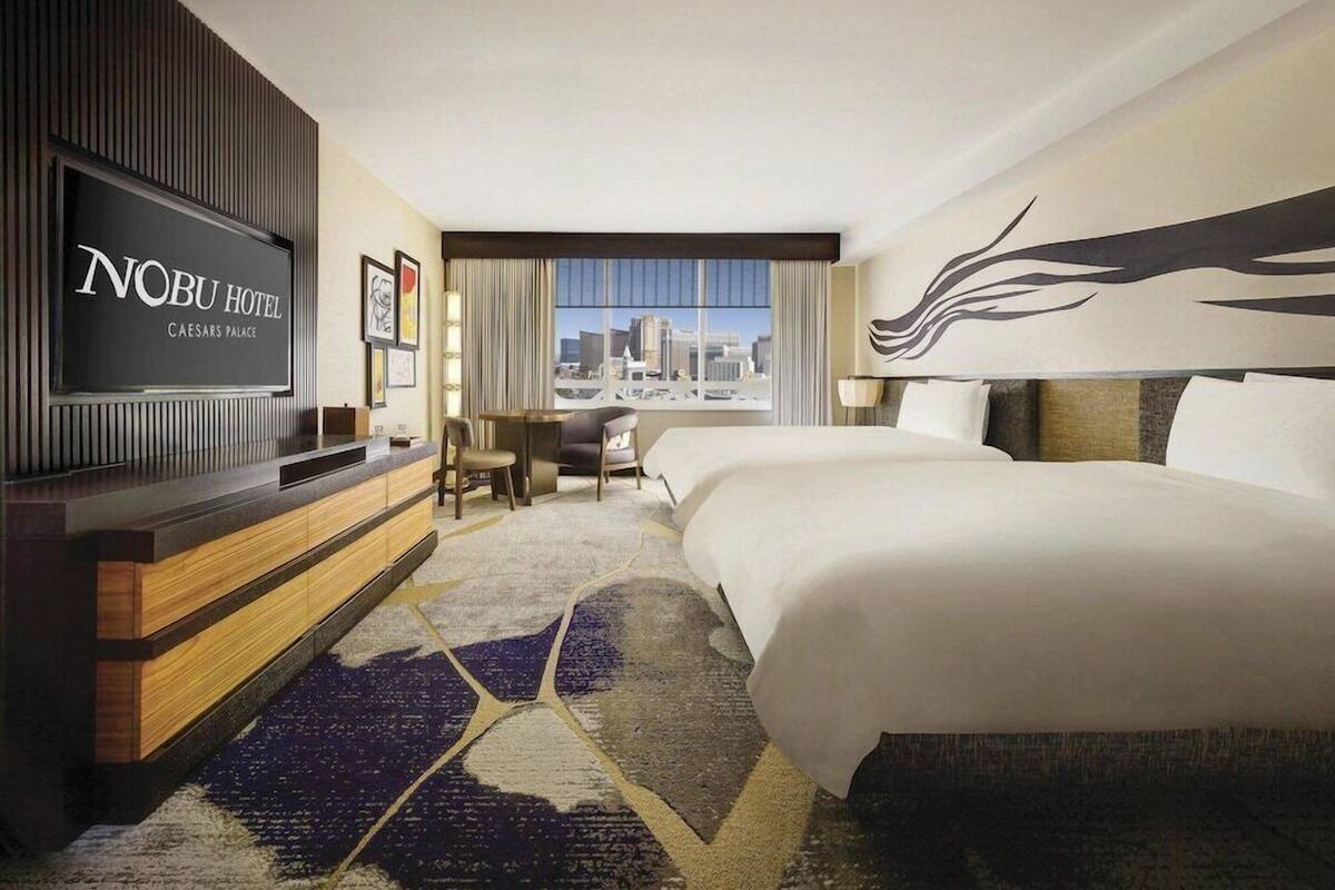 Une chambre d’hôtel avec un grand lit, un bureau, une télévision et une vue sur la ville.