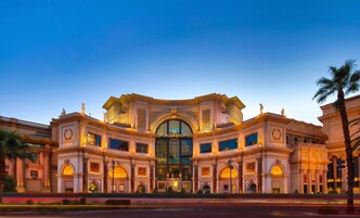 A grand building with a central entrance, columns, and statues.