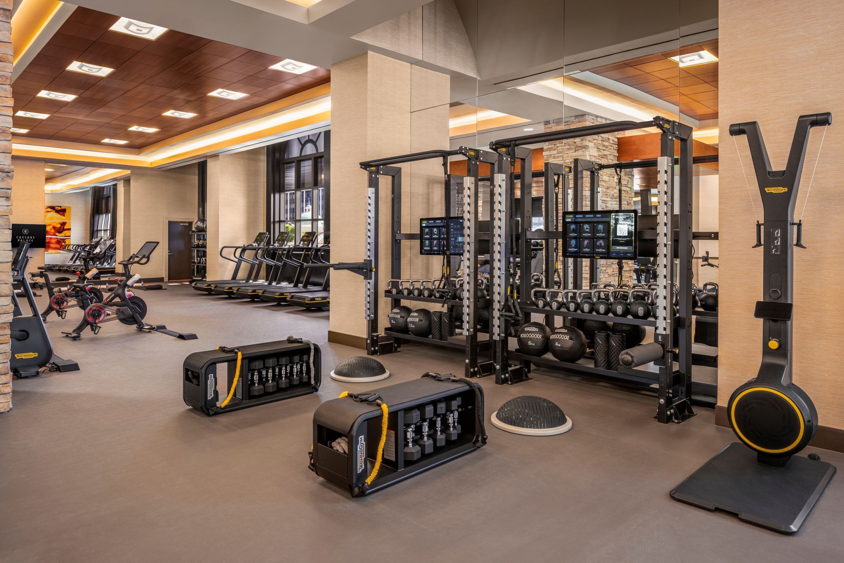 Une salle de sport équipée de tapis de course, d’appareils de musculation et de poids libres.