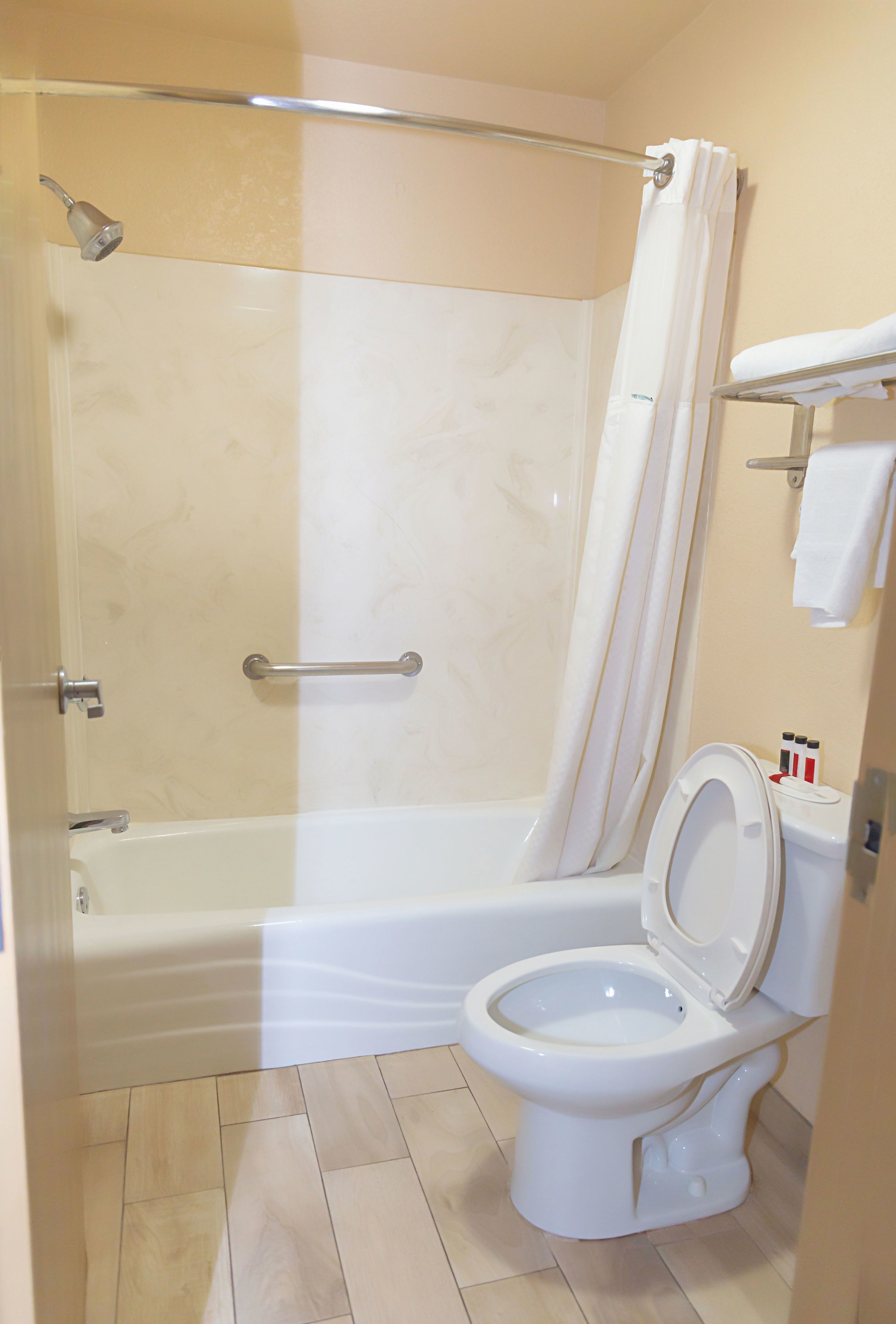Un baño con bañera, inodoro y cortina de ducha.
