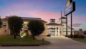 Een Days Inn & Suites gebouw met een heldere lucht in de schemering.