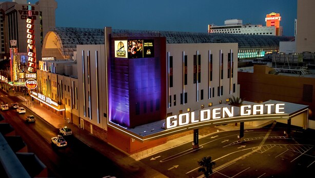 L’extérieur de l’hôtel Golden Gate, avec son enseigne bien visible, son architecture moderne et un parking où l’on peut voir des voitures.