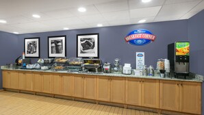 A breakfast counter with a sign reading 'Breakfast Corner,' a coffee machine, and various food items. - Baymont by Wyndham Oklahoma City/Quail Springs (Oklahoma City)