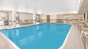An indoor swimming pool with clear water, surrounded by lounge chairs and a sunbed. - Baymont by Wyndham Oklahoma City/Quail Springs (Oklahoma City)