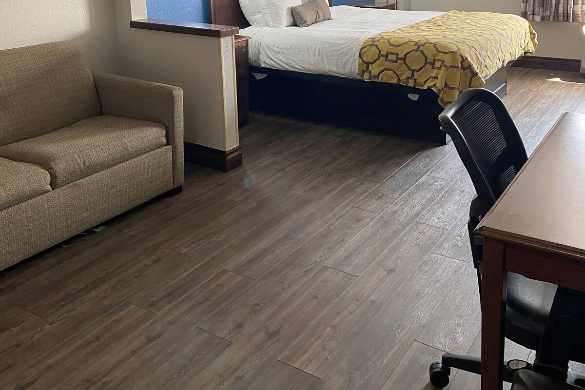 Une chambre d’hôtel avec un lit, un canapé, un bureau et une chaise.