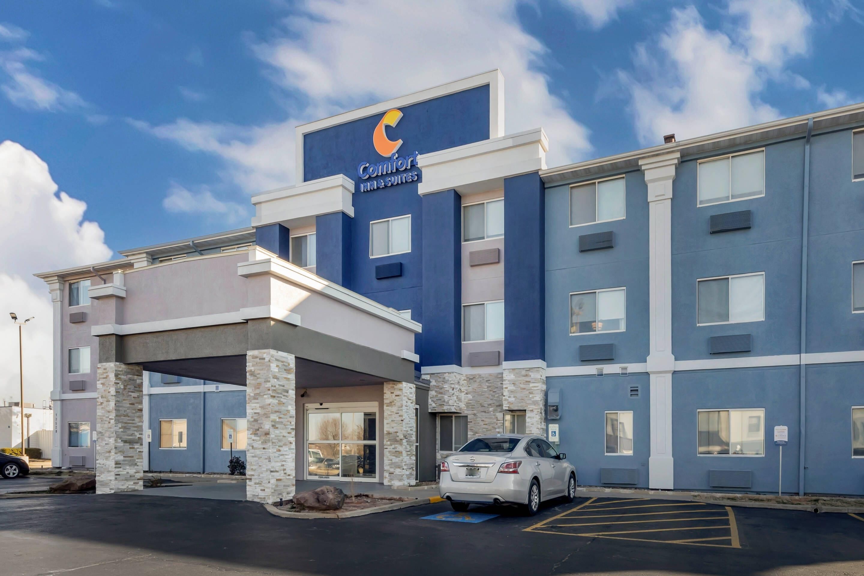 A Comfort Inn with a modern design, featuring a prominent logo, a covered entrance, and a parking area.
