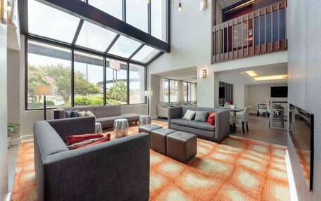 A spacious living area with large windows, a modern kitchen, and a dining area.