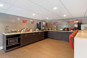 Una cocina moderna con electrodomésticos integrados, microondas y espacio para café.