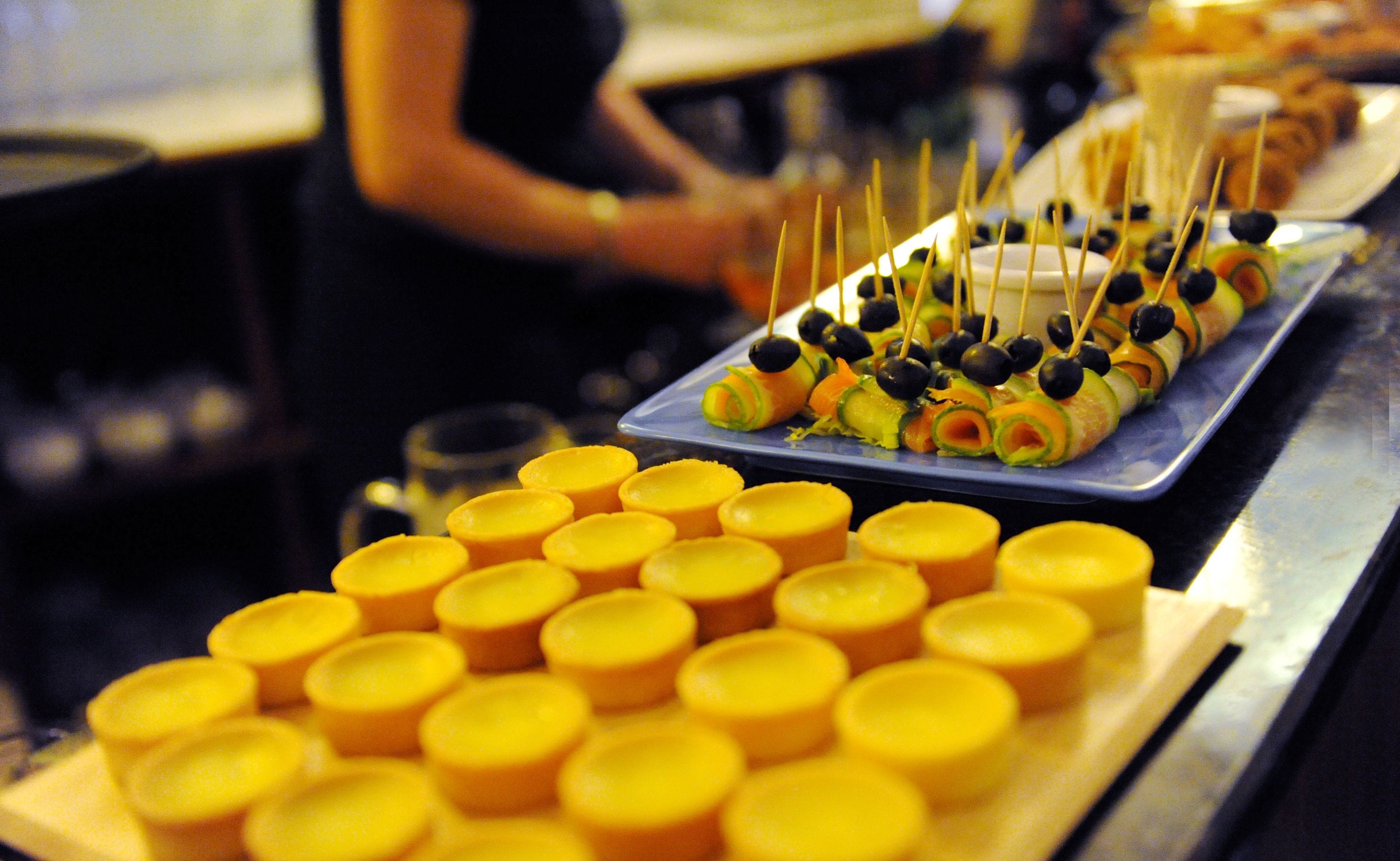 A buffet table with various food items and yellow containers.